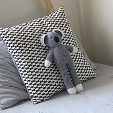 A soft grey koala toy that is hand crochet with a sleepy eyes and a black nose.